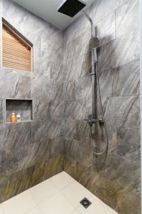 een douche in een badkamer met een stenen muur bij Ocean Villa Ukulhas Hotel & Spa in Ukulhas