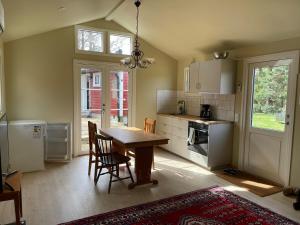 a kitchen with a wooden table and chairs in it at Gästhus nära västersjön in Munka-Ljungby