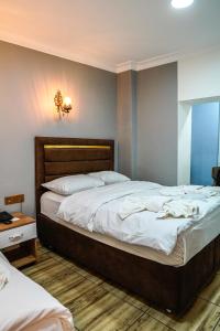 a bedroom with a large bed with white sheets at LAOS OTEL in Istanbul