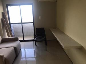 a room with a couch and a desk and a window at Condominio Biarritz Flat Residence in São Luís