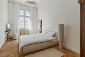 a white bedroom with a bed and a window at Adorján Apartments - The Grand Salon in Oradea