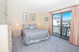 a bedroom with a bed and a balcony at PKOG09 Ocean Grove G4 in Pine Knoll Shores
