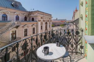 a table on a balcony with a view of a street at Adorján Apartments - The Grand Salon in Oradea