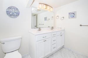 a white bathroom with a toilet and a sink at PKOG09 Ocean Grove G4 in Pine Knoll Shores +17 photos