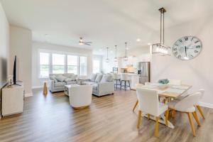 Una sala de estar con una mesa y un reloj en la pared. en Recently Built Home with View, 3 Mi to Bethany Beach, en Ocean View