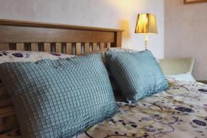 a bed with three pillows on it with a lamp at Ystumgwern Luxury Barn Conversions in Dyffryn