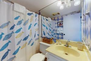 a bathroom with a sink and a toilet and a shower curtain at Ocean Grove F6 in Pine Knoll Shores +24 photos