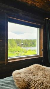 Reindeer Riverfront Aurora lodge في كيرونا: غرفة نوم مع نافذة تطل على بحيرة