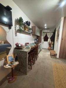 a kitchen with a counter and a bar with stools at Hannah House in Marechal Deodoro