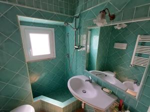 a green tiled bathroom with a sink and a mirror at Villa San Vito Amalfi Coast a timeless charme in Vietri sul Mare +43 photos