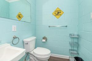 a blue bathroom with a toilet and a sink at Toes in the Sand Unit A in Atlantic Beach +11 photos