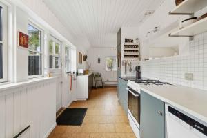 a kitchen with white walls and a ceiling with windows at Lovely Holiday Home On Bornholm in Neksø