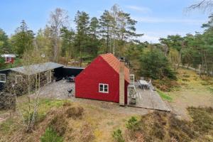 a red barn sitting on top of a field at Lovely Holiday Home On Bornholm in Neksø