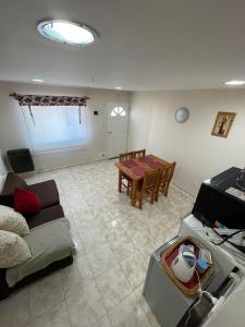 una sala de estar con un sofá y una mesa en Refugio Kooch, en Río Gallegos