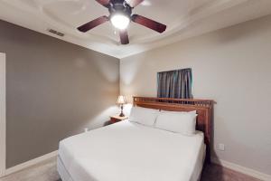 a bedroom with a bed with a ceiling fan at Sea Glass Condominiums 2 in South Padre Island