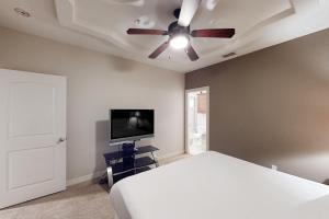 a bedroom with a white bed and a ceiling fan at Sea Glass Condominiums 2 in South Padre Island