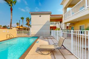 a swimming pool with a chair next to a building at Sea Glass Condominiums 2 in South Padre Island