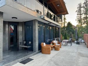 a patio with wicker chairs and tables on a house at Hotel Edelweiss in Ureki
