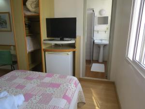 a bedroom with a bed and a television on a desk at City Hotel in Caxias do Sul