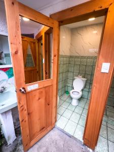 an open door to a bathroom with a toilet at Unicorn Reborn - Peaceful Rentals in San Marcos La Laguna