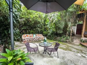 a patio with a table and chairs and an umbrella at Unicorn Reborn - Peaceful Rentals in San Marcos La Laguna