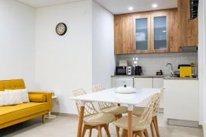 a kitchen and dining room with a white table and chairs at Casas do Freixial - Casa do Beco in Fundão