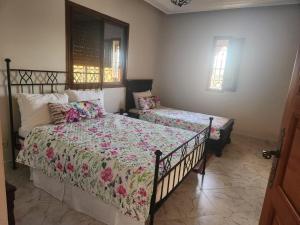 a bedroom with two beds and two windows at La dolce villa in Aït Bou Zguia +10 photos