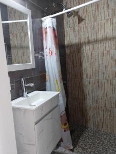 a bathroom with a sink and a shower curtain at Paraíso Relajante en Cuautla Morelos in Cuautla Morelos