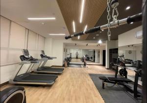 a gym with treadmills and a row of exercise bikes at The Gulberg Apartments in Lahore