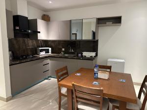 a kitchen with a wooden table and chairs in a room at The Gulberg Apartments in Lahore