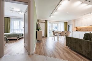 an open living room with a kitchen and a dining room at Gdańsk Apartments Motława Garden Family Suite in Gdańsk