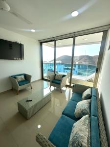 salon z niebieską kanapą i telewizorem w obiekcie Apartamento completo en Club de Playa en Santa Marta w mieście Santa Marta