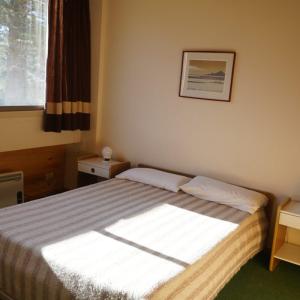 a bedroom with a bed with a picture on the wall at Cirrus Apart in Las Lenas +49 photos
