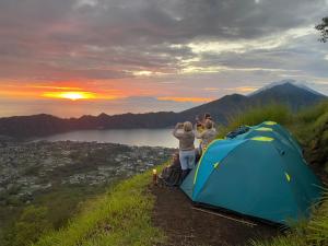 クブペンロカンにあるMount Batur Camping on Summitのテント横の丘の上に立っている人々のグループ