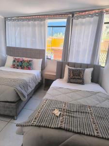 a bedroom with two beds and a window at intikilla hostal in Ollantaytambo