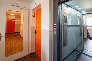 a corridor in an office building with colorful doors at easyHotel Zürich City Main Station in Zurich