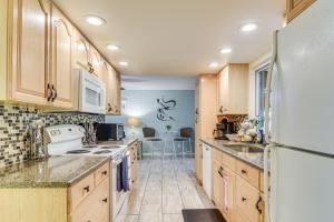 クリアウォーターにある6 Mi to Clearwater Beach Home with Furnished Lanaiの木製のキャビネットと白い冷蔵庫を備えたキッチン