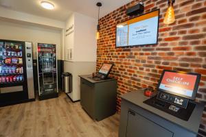 a shop with a brick wall and a cash machine at easyHotel Zürich City Main Station in Zurich