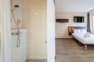 a bathroom with a shower and a bed in a room at easyHotel Zürich City Main Station in Zurich