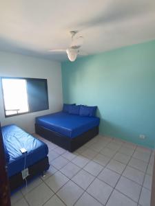 Ένα ή περισσότερα κρεβάτια σε δωμάτιο στο Apartamento pé na areia com sacada e garagem 2 banheiros