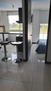 a kitchen with two stools and a counter in a room at Alojate a 3 minutos del Parque del Cafe in Montenegro