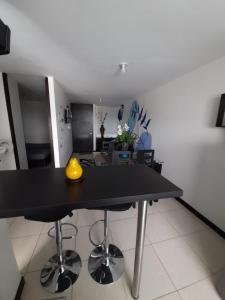 a table with a yellow vase on it in a room at Alojate a 3 minutos del Parque del Cafe in Montenegro