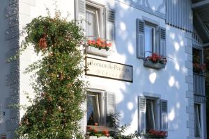 a white building with flower boxes and a sign on it at Romantic-Pension Albrecht - Villa next to UNESCO World Heritage - since 1901 in Hohenschwangau +56 photos