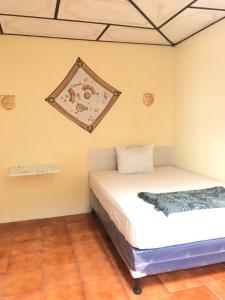 a bedroom with a bed and a picture on the wall at Hospedaje Económico Antigua in Antigua Guatemala