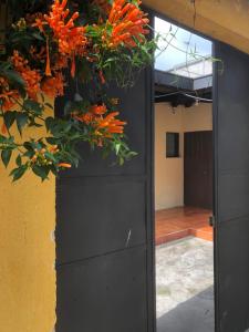 a black door with a flower arrangement on it at Hospedaje Económico Antigua in Antigua Guatemala