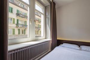 ein Schlafzimmer mit einem Bett und einem großen Fenster in der Unterkunft easyHotel Zürich City Centre in Zürich