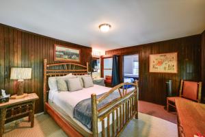 a bedroom with a bed and a table and a chair at Hatchs Landing Lake Ostego Home in Cooperstown