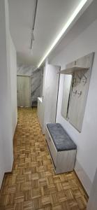 an empty room with a bench on a wooden floor at Lux Apartman Stojanović in Belgrade