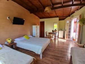 a bedroom with two beds and a dining room at Solar del Mar in Praia do Rosa