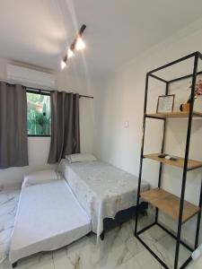 a bedroom with a bed and a shelf at Casa Nova Centro de Penedo-Quitinete in Penedo